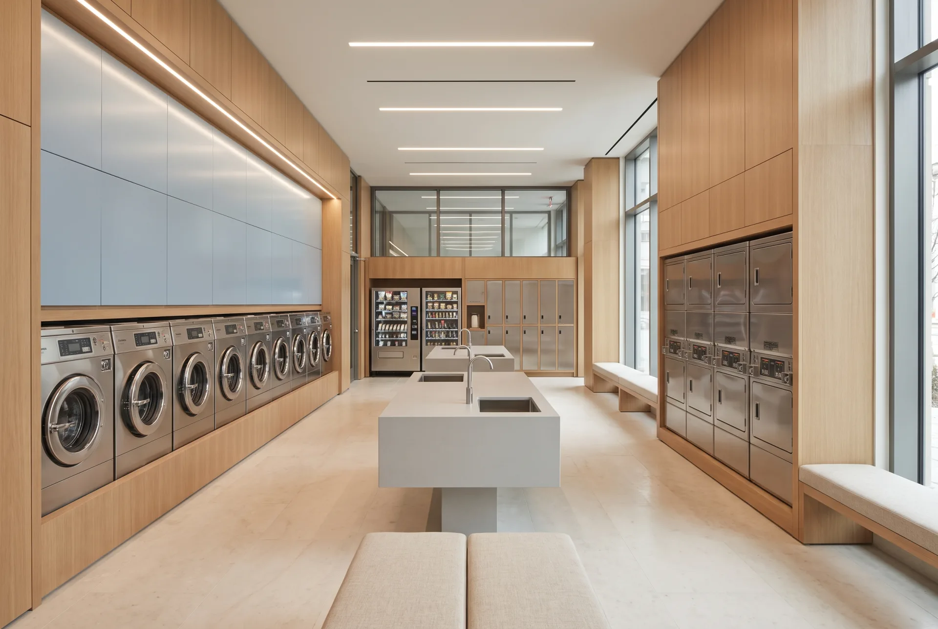 A flagship laundry and garment-care amenity suite with twenty washers, twelve stacked dryers, honed stone flooring, full-height white oak millwork and an integrated locker bank.